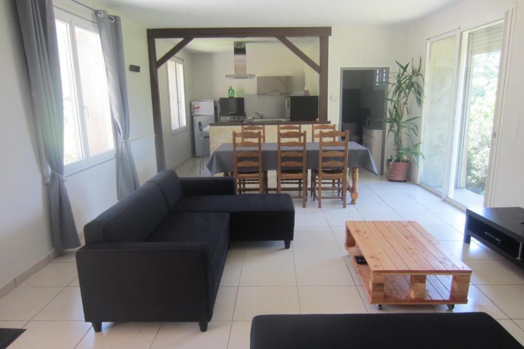 sala de estar con sofá y mesa en Maison Au Milieu De La Foret, en Labastide-Rouairoux