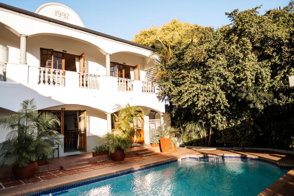 a villa with a swimming pool in front of a building at Devereux Lodge in East London