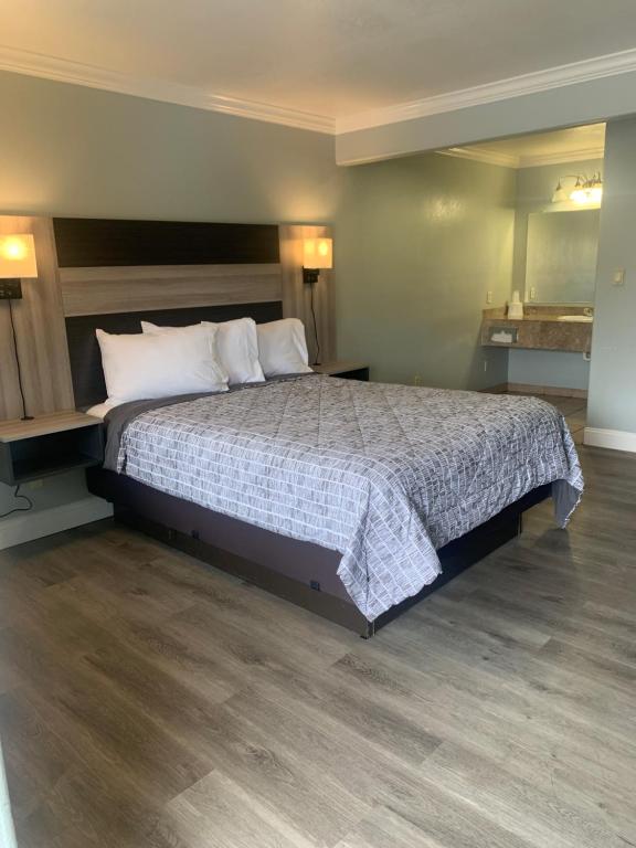 1 dormitorio con 1 cama grande con almohadas blancas en Monterey Oceanside Inn, en Monterey