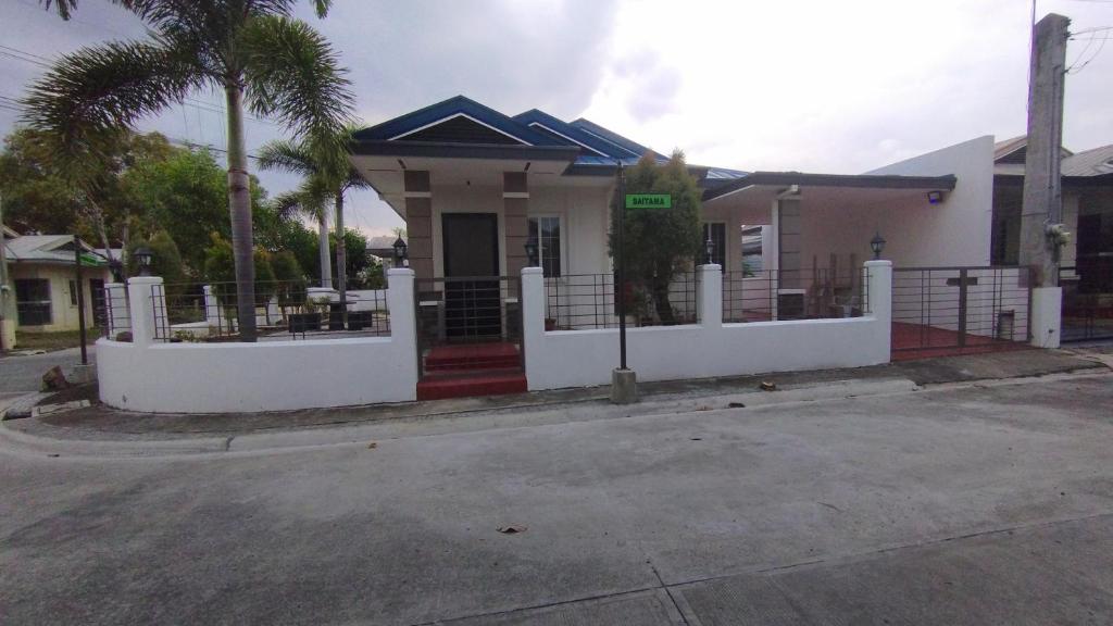 una casa blanca con una puerta y una calle en 2 Bedroom House in Bambu Estates Mintal Near Vista Mall and UP Mindanao en Dávao
