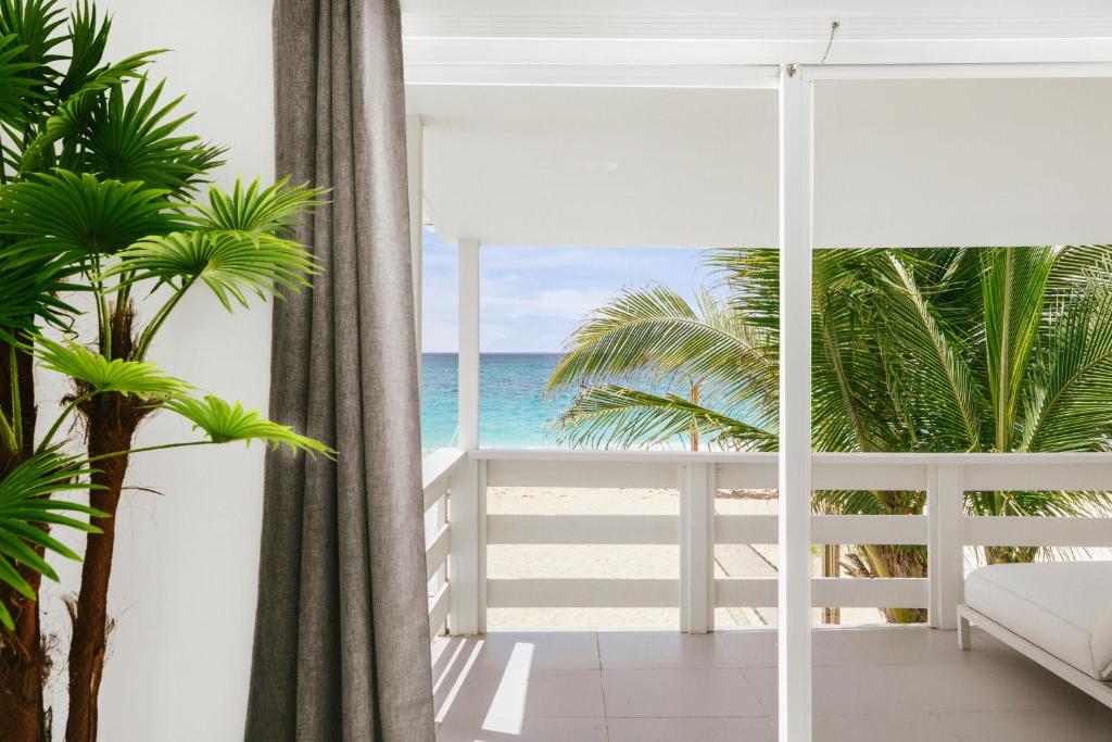 a room with a view of the beach and the ocean at CocoVaa Beach Boutique Hotel in Simpson Bay