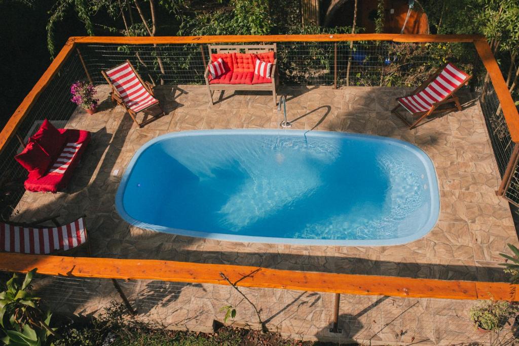 bañera de hidromasaje en un patio con 2 sillas en Recanto de Encantos, en Campos do Jordão