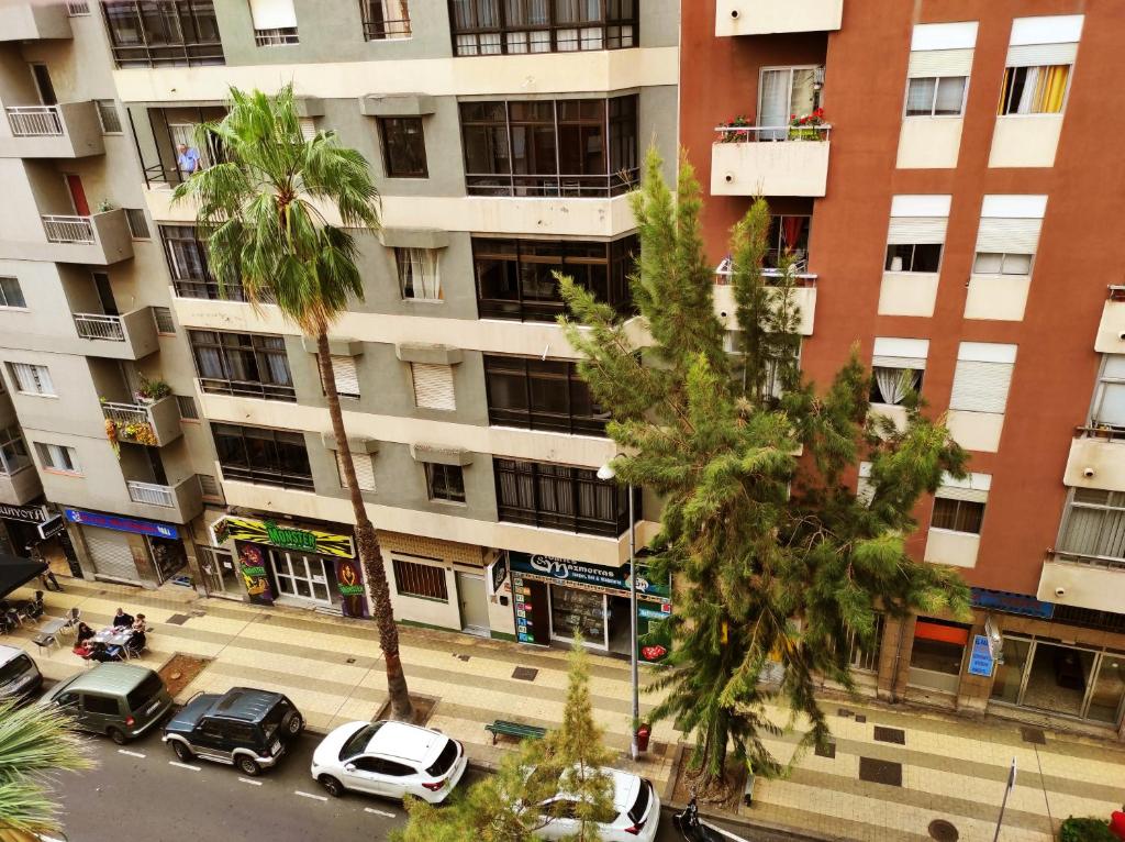 un immeuble d'appartements avec des voitures garées dans un parking dans l'établissement Apartamentos Carrillo 6, à Santa Cruz de Tenerife