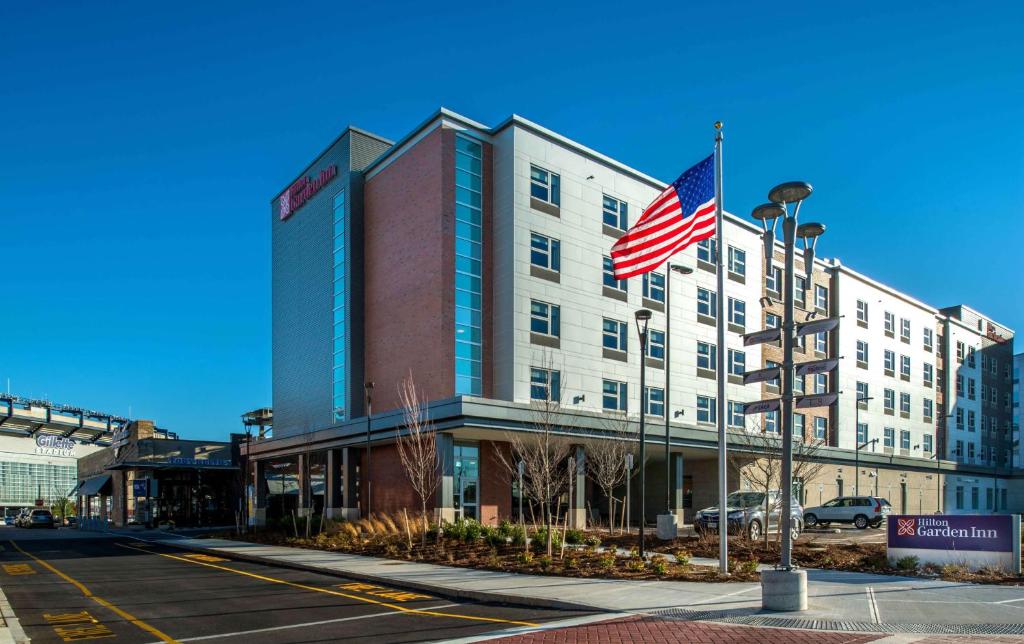 uma bandeira americana a voar em frente a um hotel em Hilton Garden Inn Foxborough Patriot Place em Foxborough