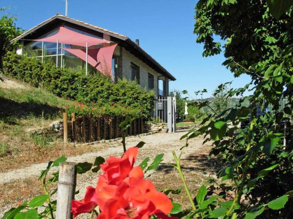 une maison avec une fleur rouge devant elle dans l'établissement Ca' Mia - Casa vacanze nelle vigne del Barolo, à Serralunga d'Alba