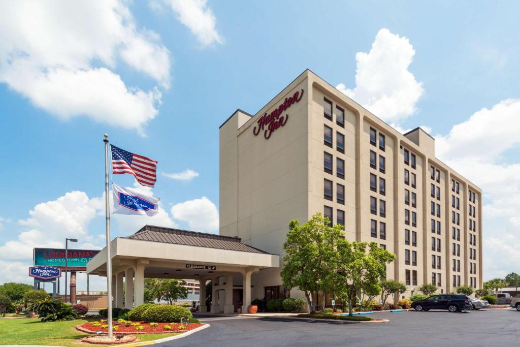 una vista exterior de un hotel con bandera americana en Hampton Inn I-10 & College Drive en Baton Rouge