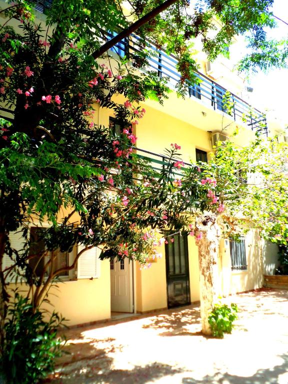 a yellow building with pink flowers in front of it at Icthyoessa in Agios Kirykos