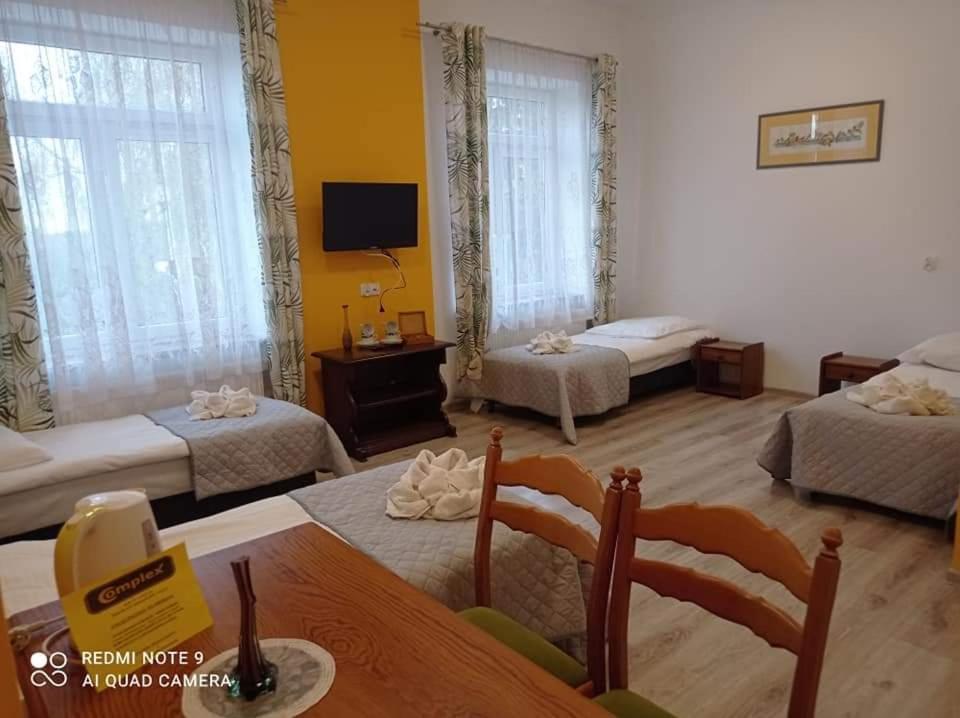 een woonkamer met 2 bedden en een tafel bij Centrum Wypoczynkowe COMPLEX in Mąkoszyn