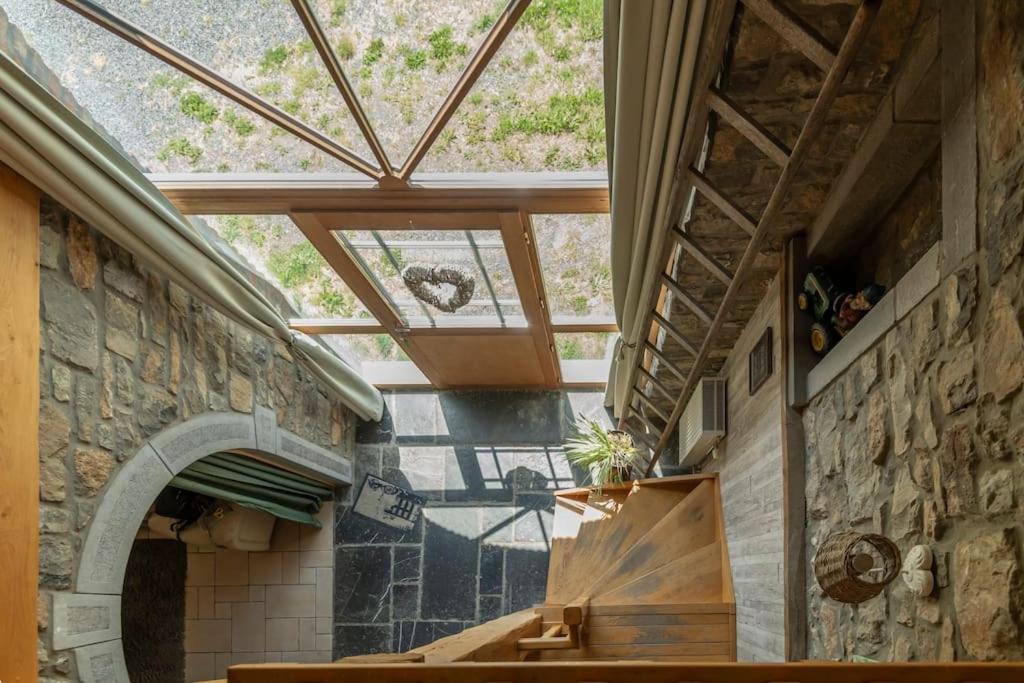 a room with a large window and a stone wall at Les 4 bras Maison de vacances in Beauraing