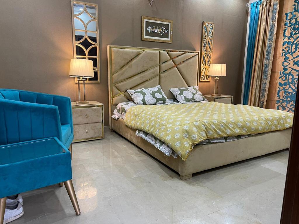 sypialnia z łóżkiem i niebieskim krzesłem w obiekcie Three Bedroom Villa w mieście Lahaur