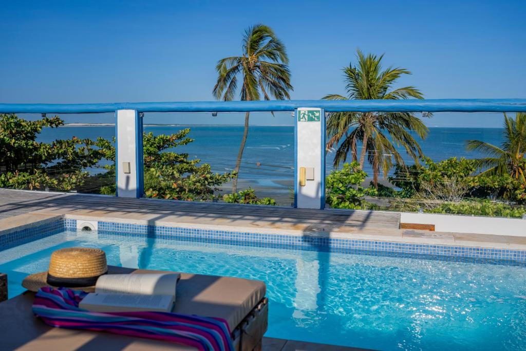 a swimming pool with a view of the ocean at Vila Maria Pousada in Jericoacoara