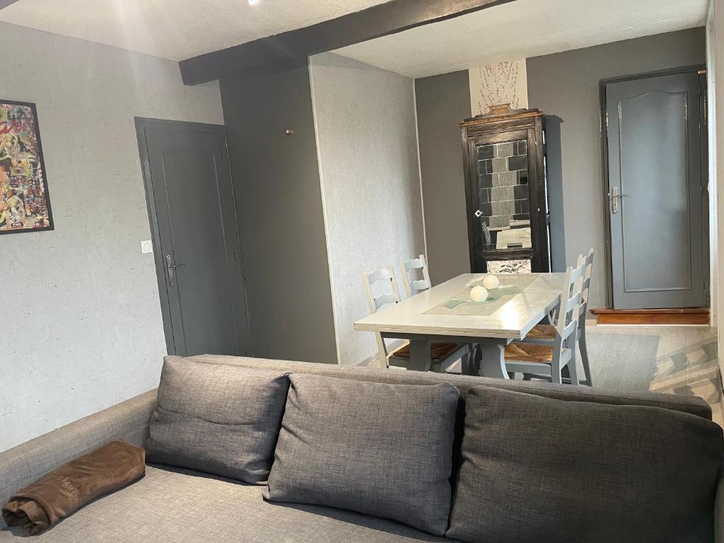 un salon avec un canapé et une table dans l'établissement Gite La Choupette, à Saint-Hilaire-du-Harcouët
