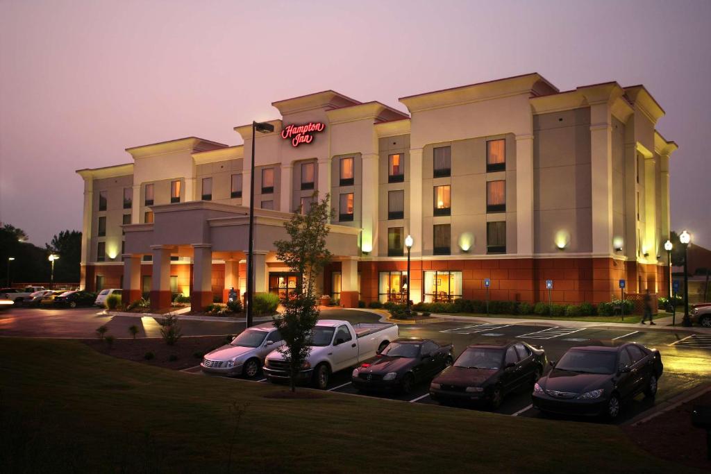 un hôtel avec des voitures garées dans un parking dans l'établissement Hampton Inn Carrollton, à Carrollton