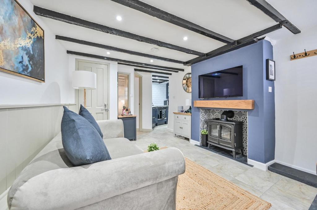 a living room with a couch and a fireplace at Luxury Couple's Getaway with River Views and Parking in Polperro