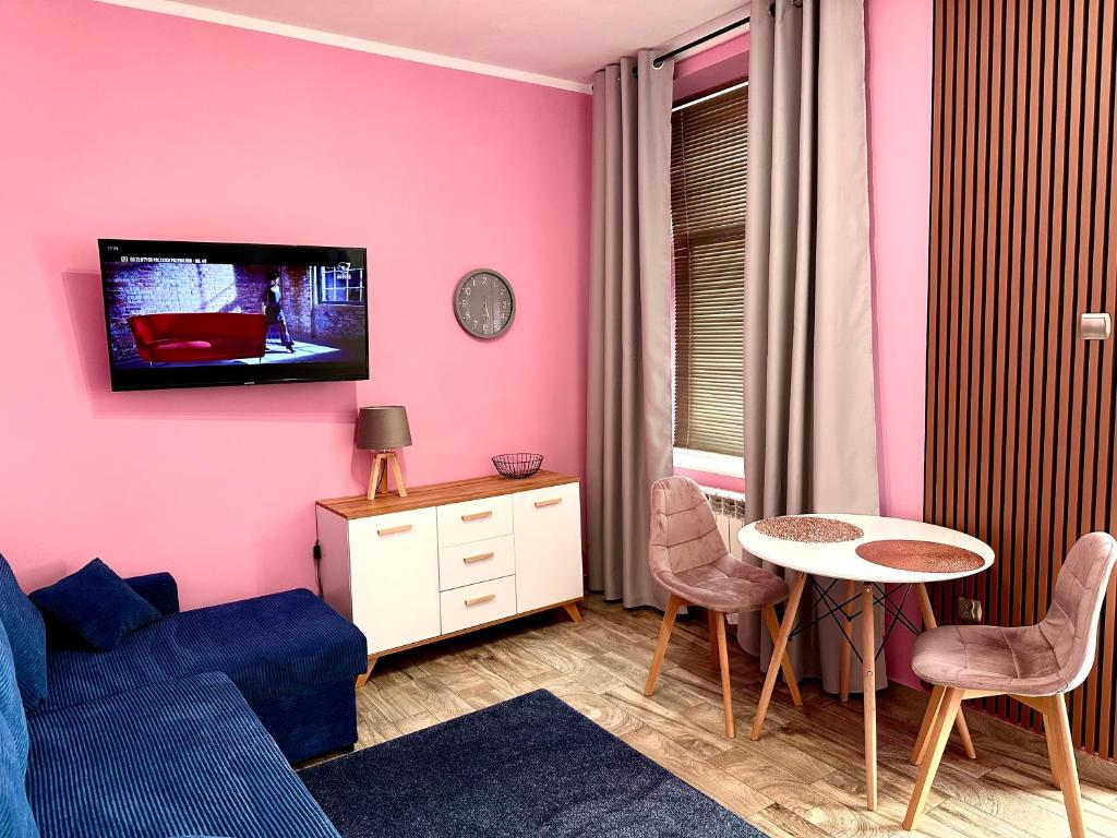 uma sala de estar com um sofá azul e uma mesa em Apartament Krasnostawski em Krasnystaw