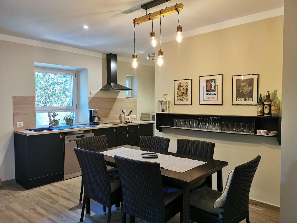 une cuisine et une salle à manger avec une table et des chaises dans l'établissement L'althea, à Carcassonne