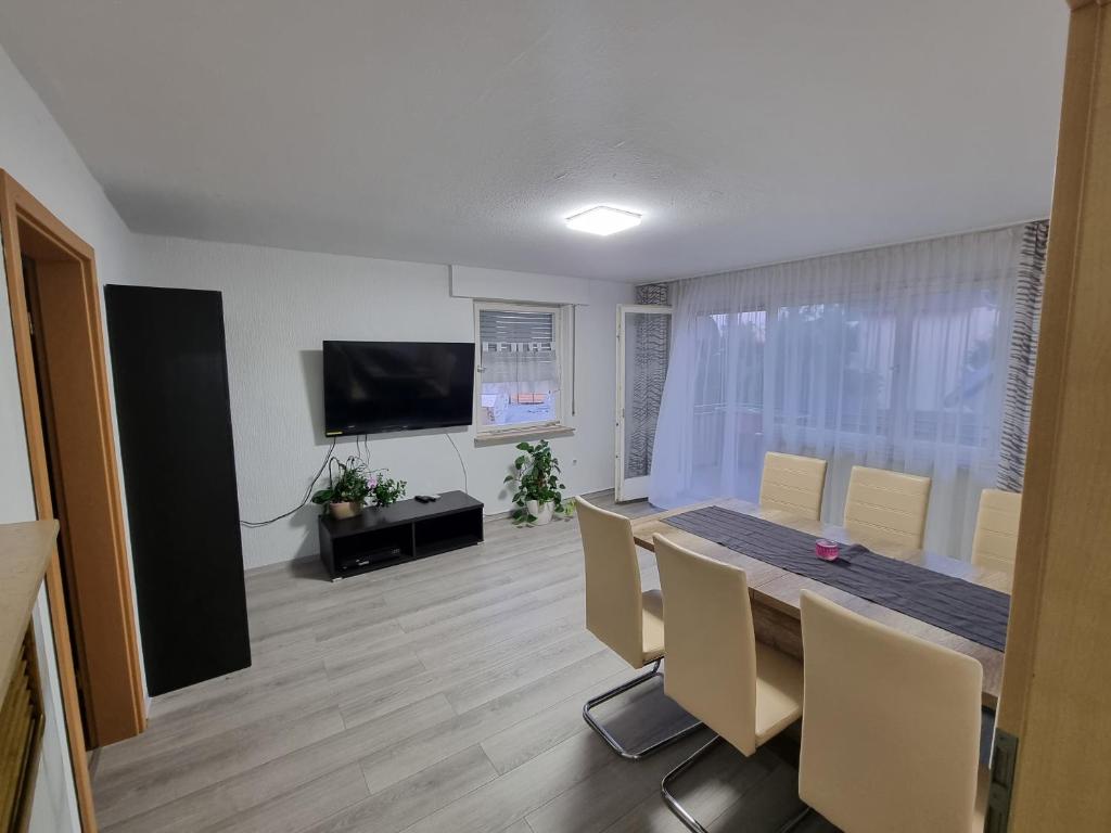 a dining room with a table and chairs and a television at Ferienwohnung Safi in Sachsenheim