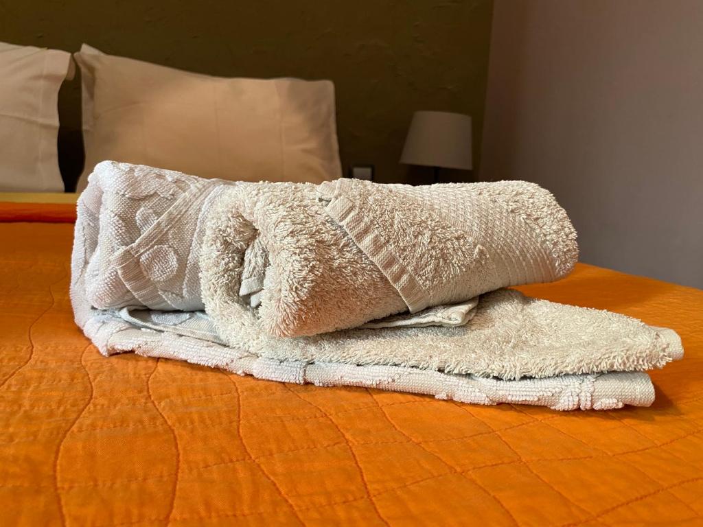 une pile de serviettes assises au-dessus d'un lit dans l'établissement SoHoAthine Apartment, à Athènes