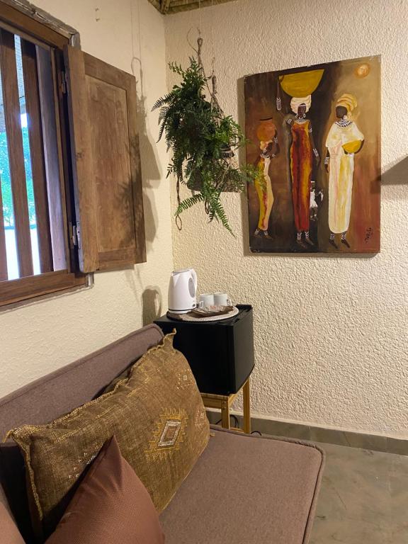 a living room with a couch and a painting on the wall at Toubacouta Lodges in Toubakouta