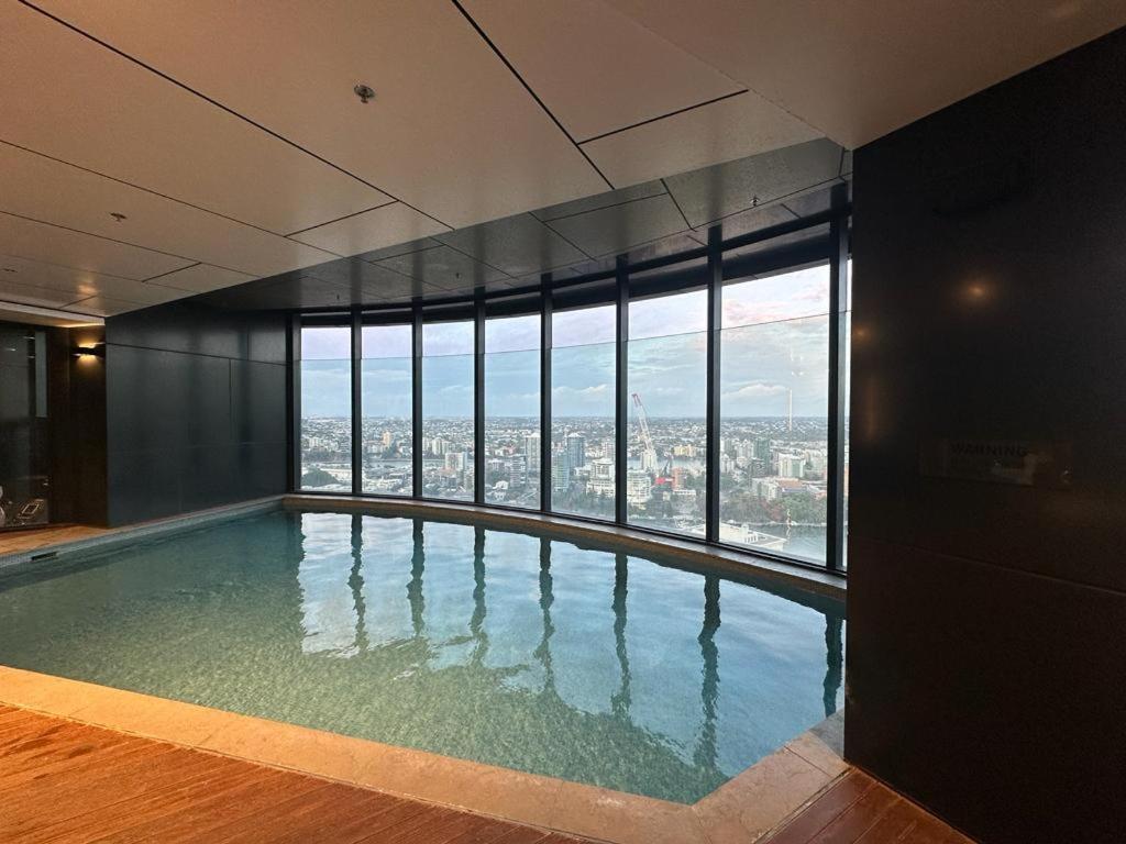 a swimming pool in a building with a view of the city at Brisbane Skytower By Utopia in Brisbane