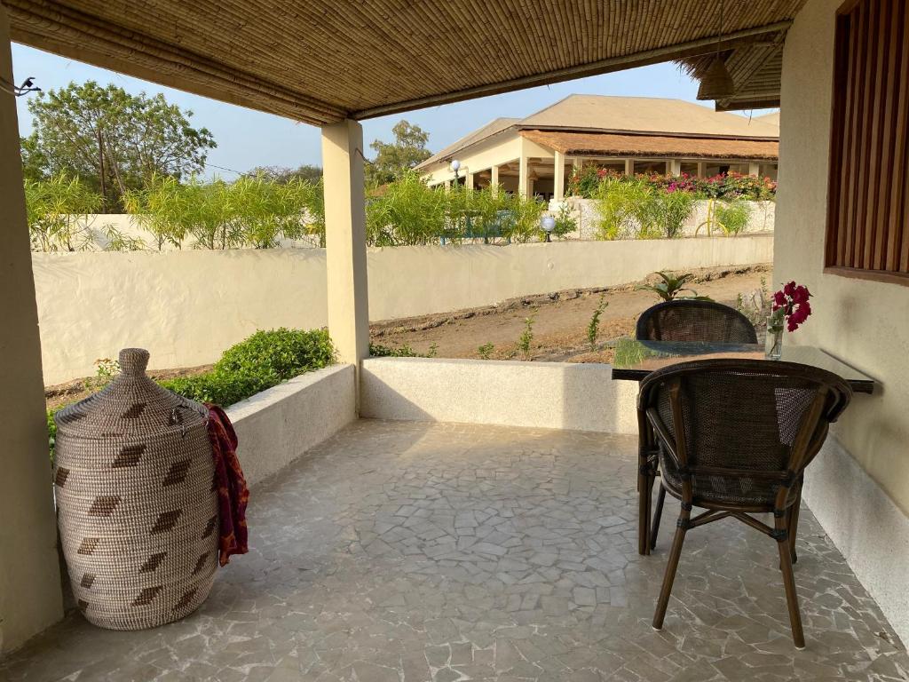 a patio with a table and a chair on a porch at Toubacouta Lodges in Toubakouta