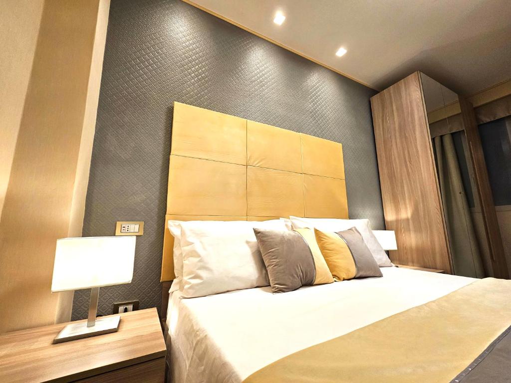 a bedroom with a bed with a headboard and a lamp at Astoria Supreme - Modern Boutique Suites in Lecce