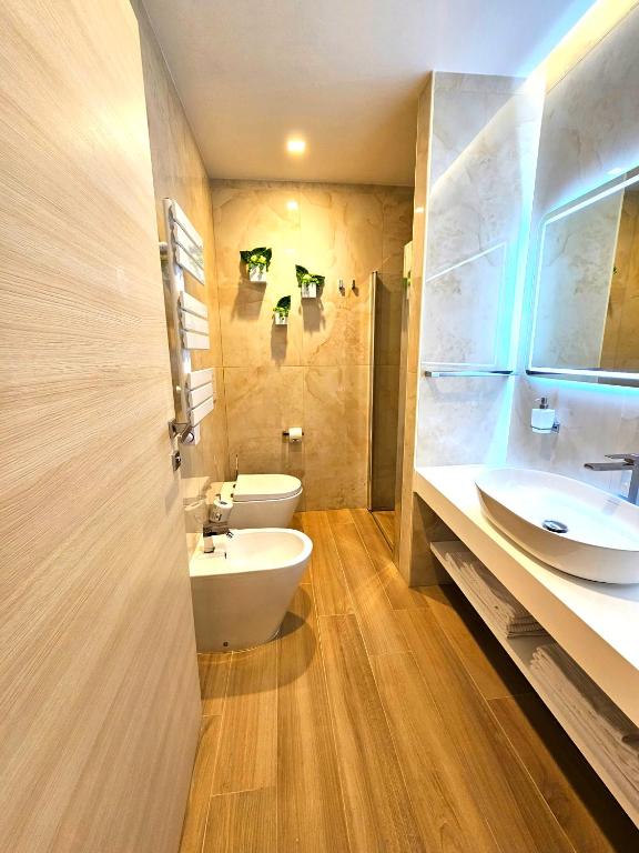 a bathroom with a white toilet and a sink at Astoria Supreme - Modern Boutique Suites in Lecce