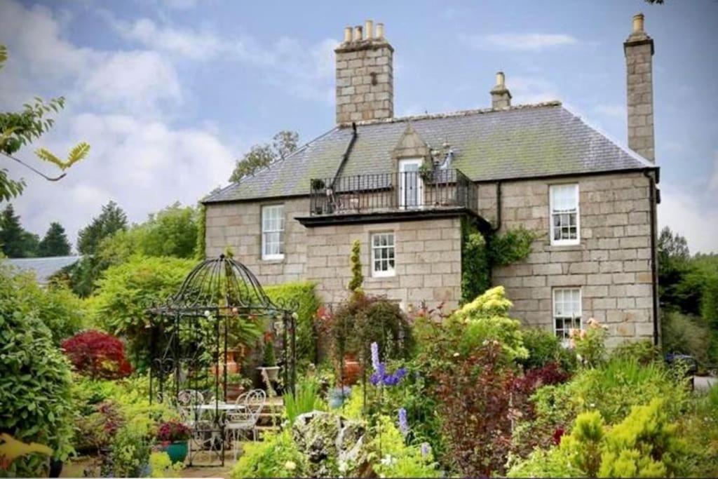 a large stone house with a garden in front of it at Prestigious Georgian Mansion 