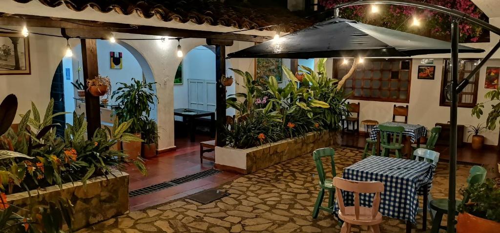 Un patio con una sombrilla y una mesa y sillas. en Casa Naturhola, en Villa de Leyva