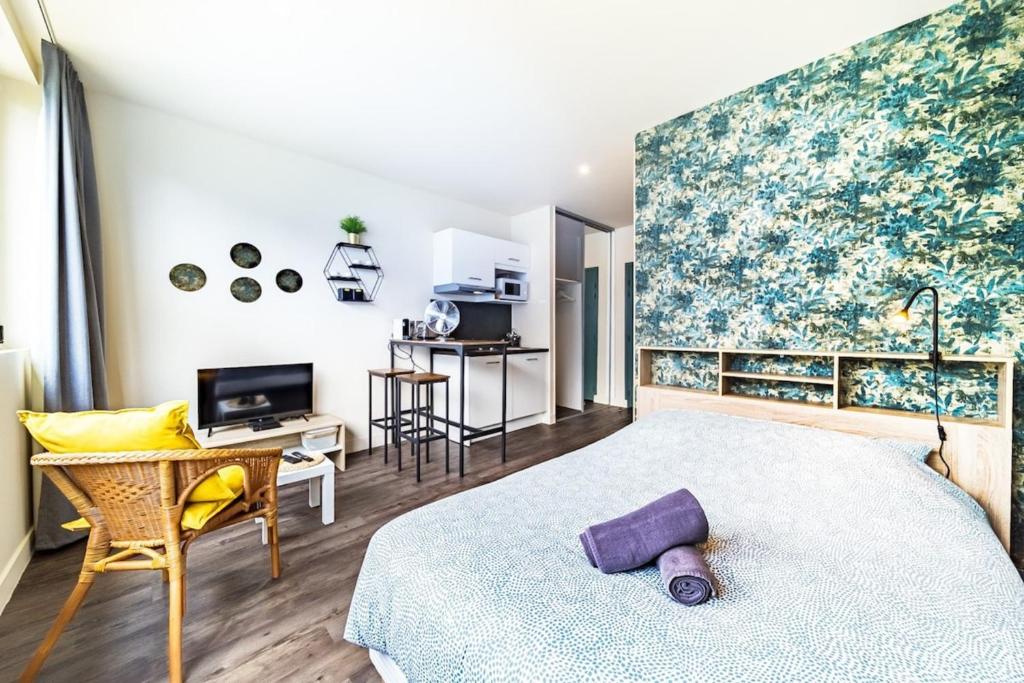 een slaapkamer met een bed, een bureau en een televisie bij Le Guérin cosy studio 2 pers Tête d'Or in Villeurbanne