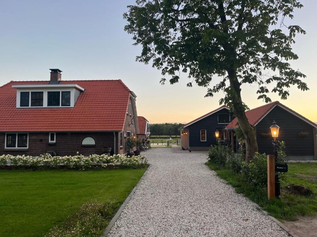 Bed & Breakfast Hoeve Happiness في فورتهاوزن: منزل بسقف احمر وممر