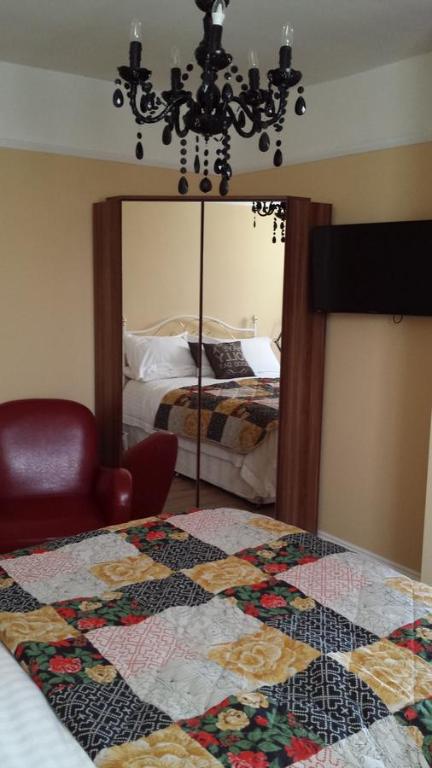 a bedroom with a quilt on a bed and a mirror at The Railway Inn Westerfield in Ipswich