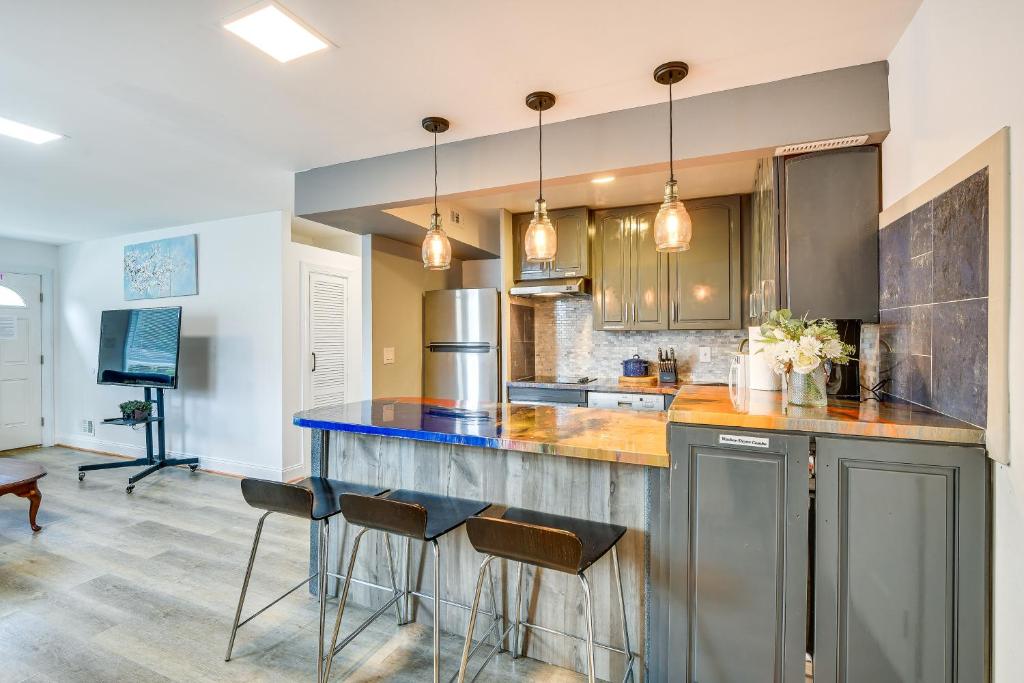 una cocina con encimera con taburetes. en Convenient Glenarden Home - 3 Mi to FedEx Field!, en Glenarden