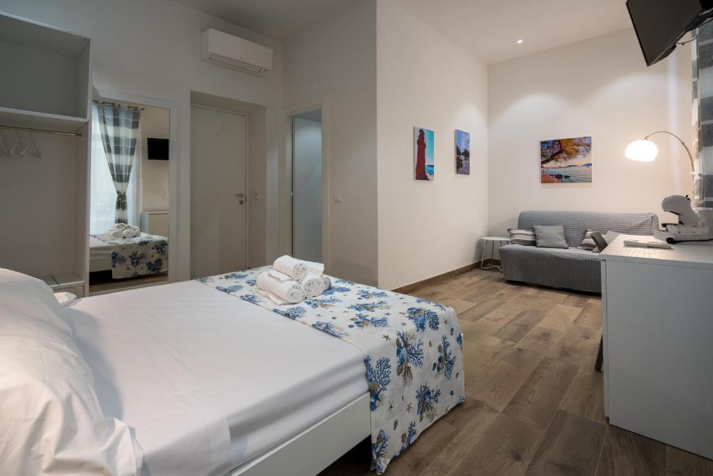 biała sypialnia z łóżkiem i kanapą w obiekcie All'Imbarco w mieście La Spezia