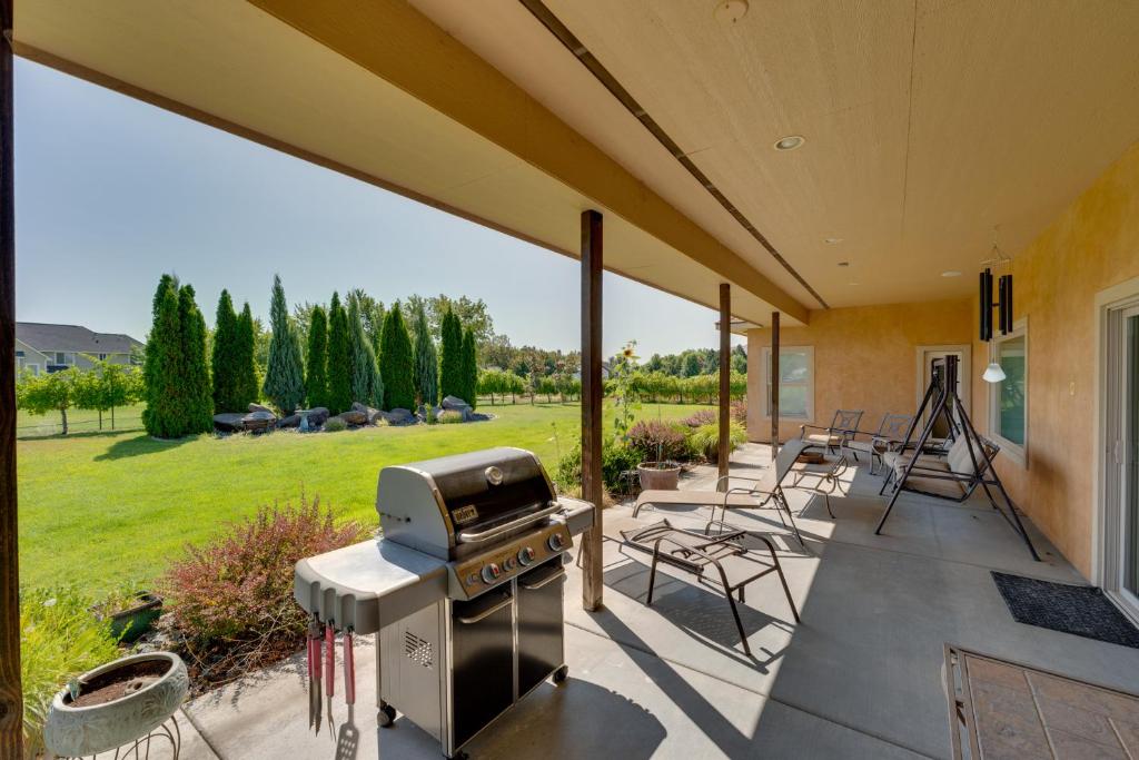een patio met een grill en stoelen en een gazon bij West Richland Home with Vineyard and Mountain Views! in West Richland
