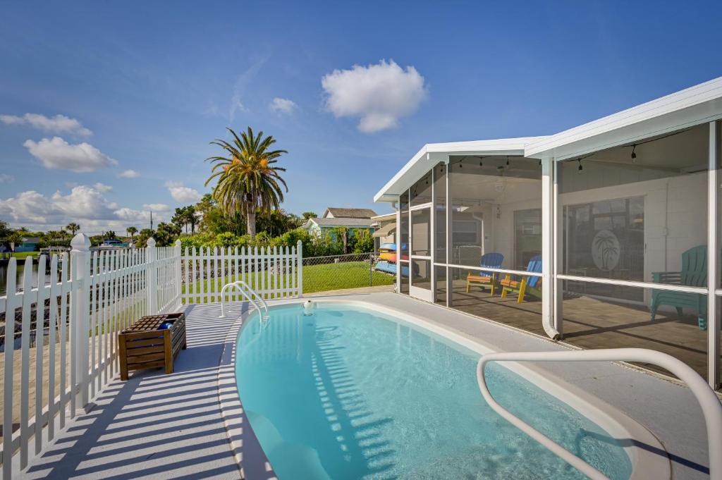 a house with a swimming pool next to a white fence at New Port Richey Oasis with Private Pool! in New Port Richey