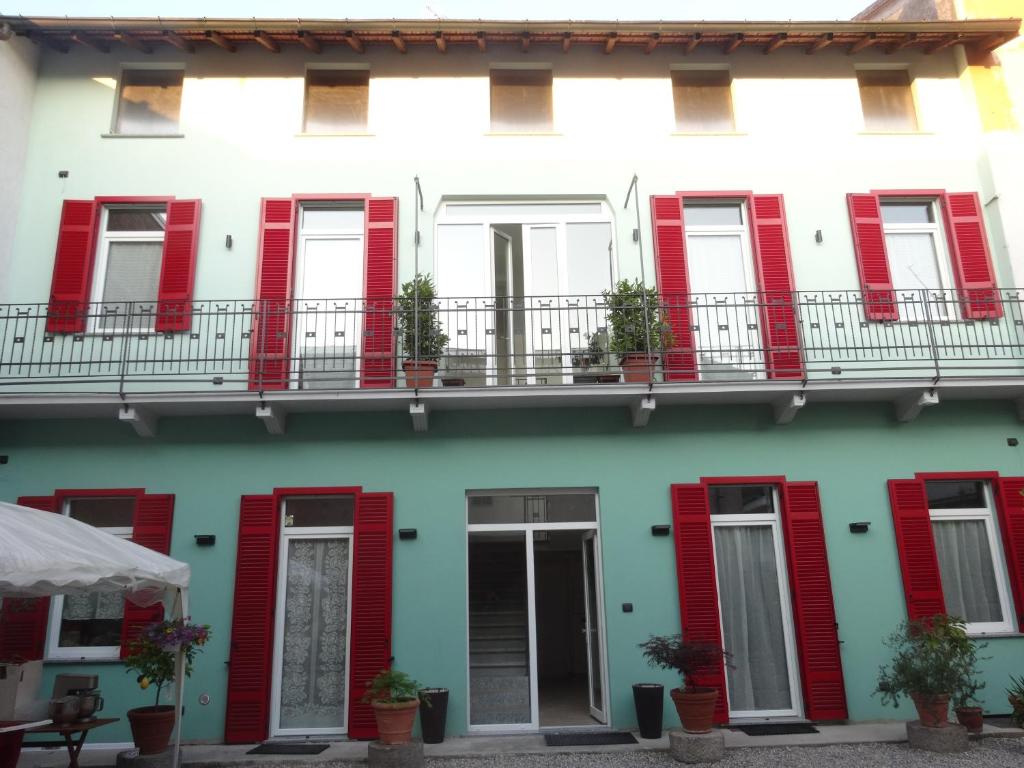 una facciata di un edificio con persiane rosse di Notte di Note - home hospitality a Busto Arsizio
