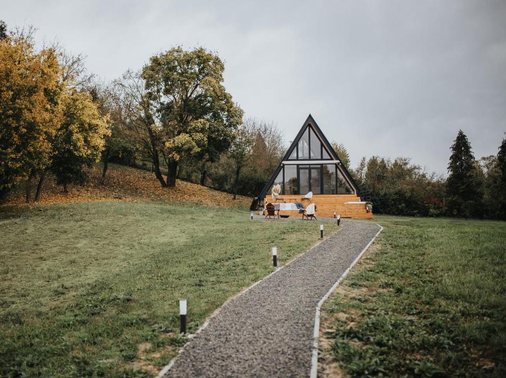 una casa in cima a un campo con una strada di Grafit Kabin a Nagykanizsa