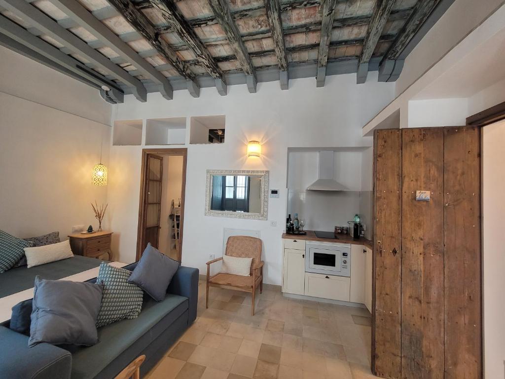 een woonkamer met een bank en een keuken bij Casa del Museo - Agua in Medina Sidonia