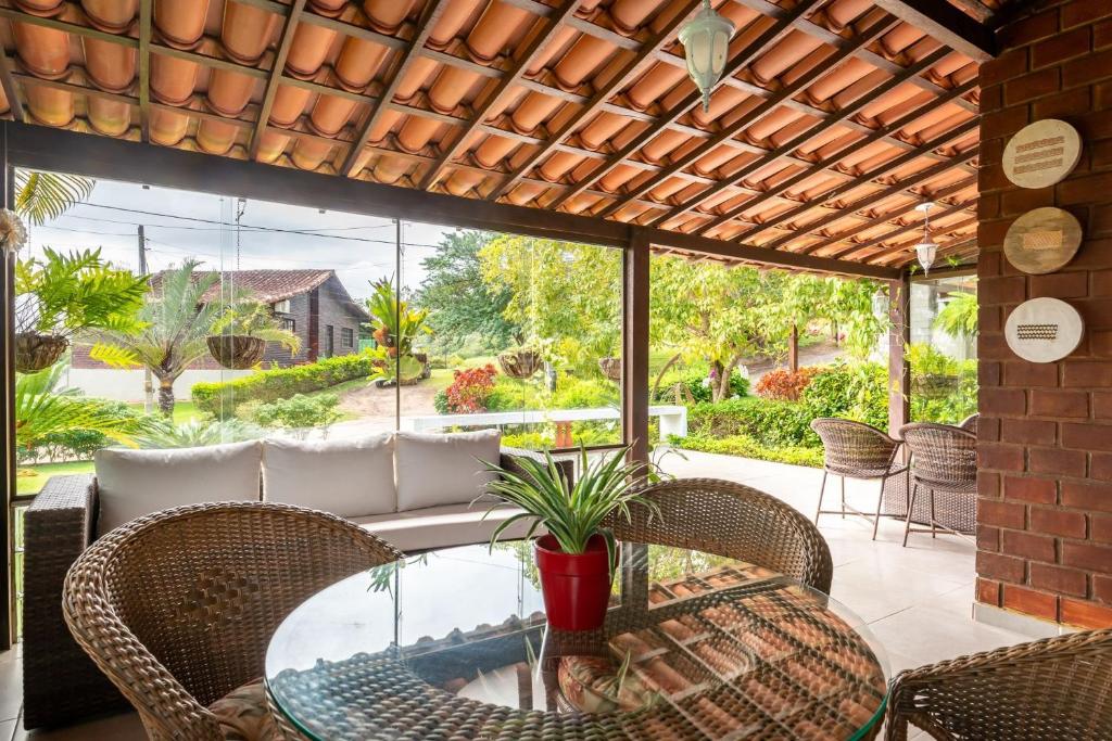 eine Terrasse mit Glastisch und Korbstühlen in der Unterkunft Refúgio Familiar-Casa de Campo em Gravata-3QTS-065 in Gravatá