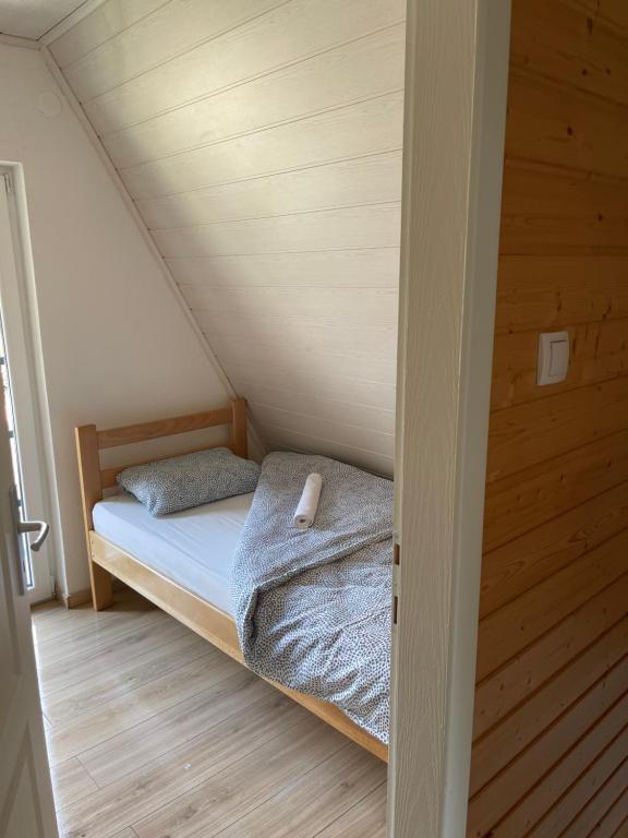 um pequeno quarto com uma cama no sótão em Vikendice Ana em Žabljak