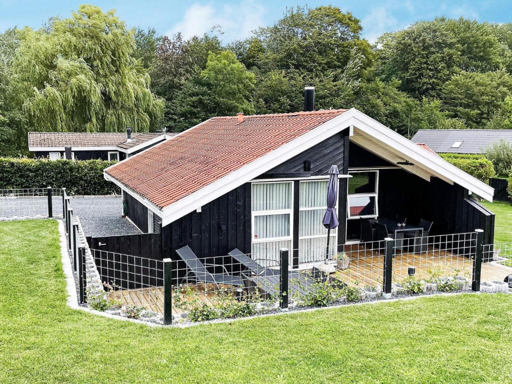 Egernsundにある6 person holiday home in Egernsundの周囲の柵を持つ白黒の建物