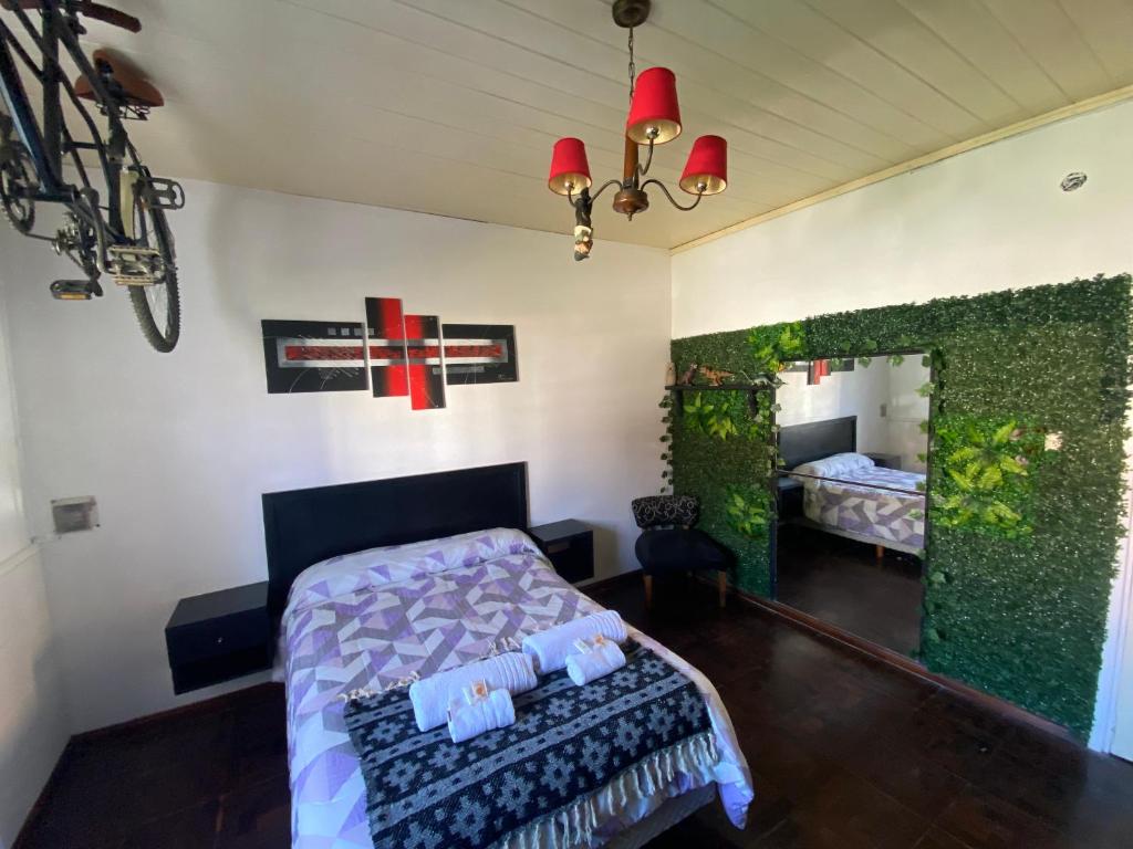 ein Schlafzimmer mit einem Bett und einem Kreuz an der Wand in der Unterkunft Exclusiva casa céntrica in Chascomús