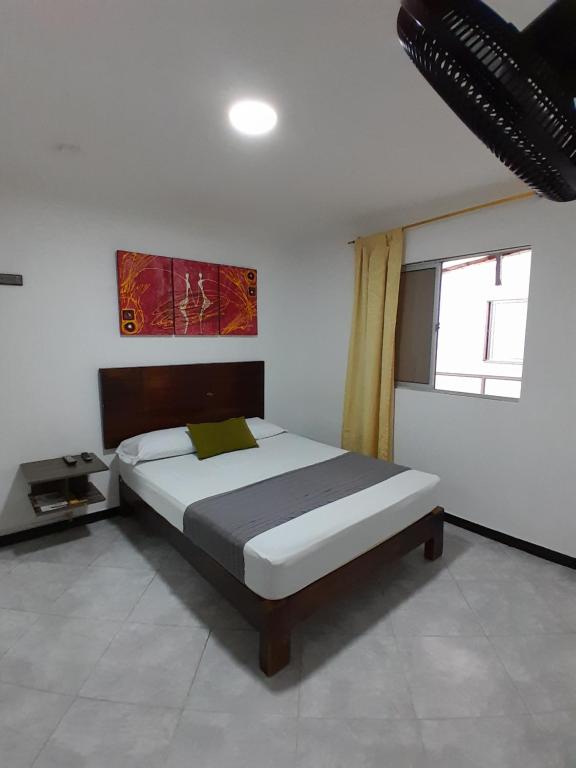 Schlafzimmer mit einem Bett und einem Fenster in der Unterkunft Hotel Palermo Real in Medellín