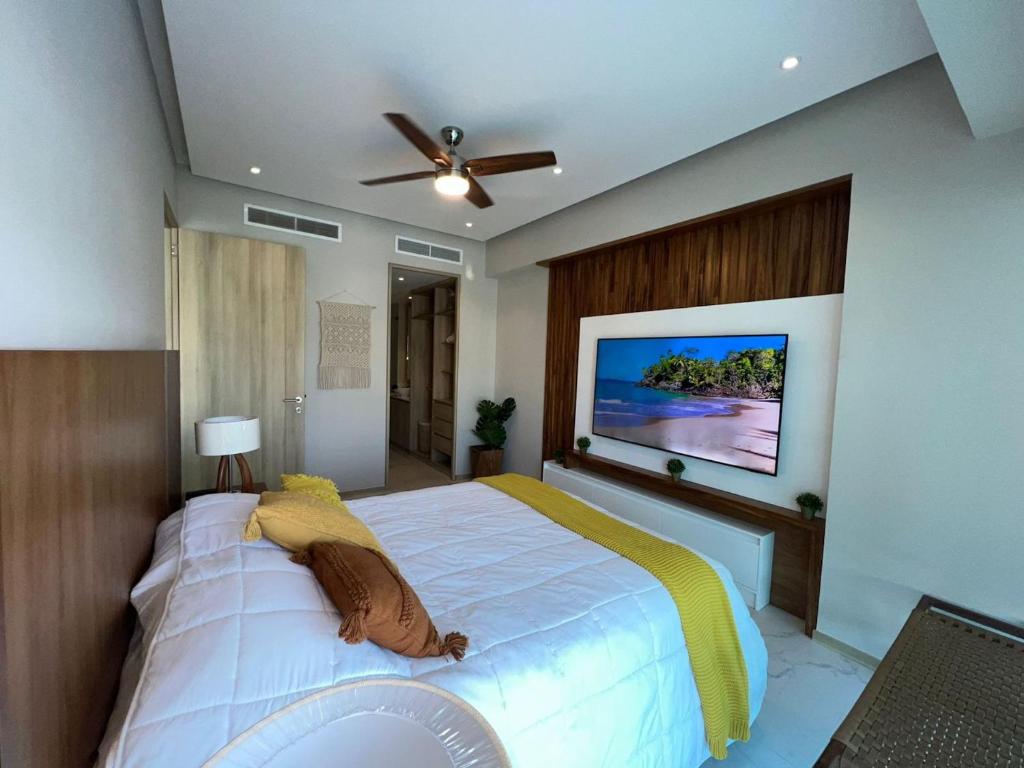 een slaapkamer met een groot bed en een televisie aan de muur bij Marítima Golf Luxury Department 2BR in Bucerías