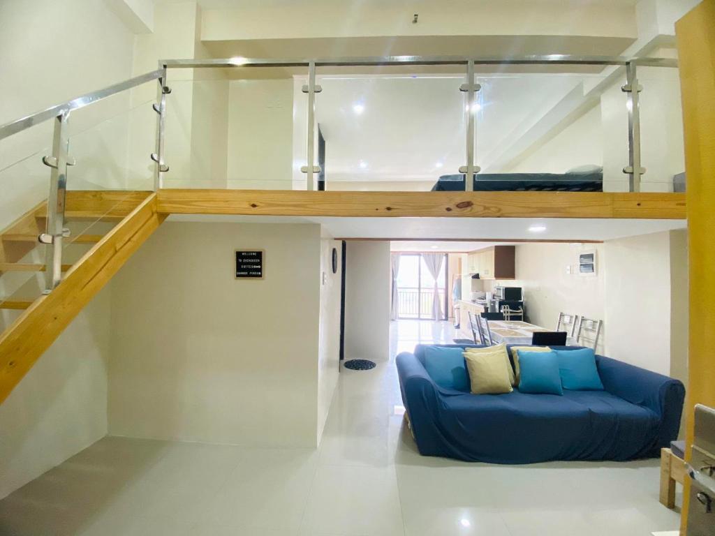 un salon avec un canapé bleu et une mezzanine dans l'établissement Evergreen Suites Baguio Condo Home Loft, à Baguio