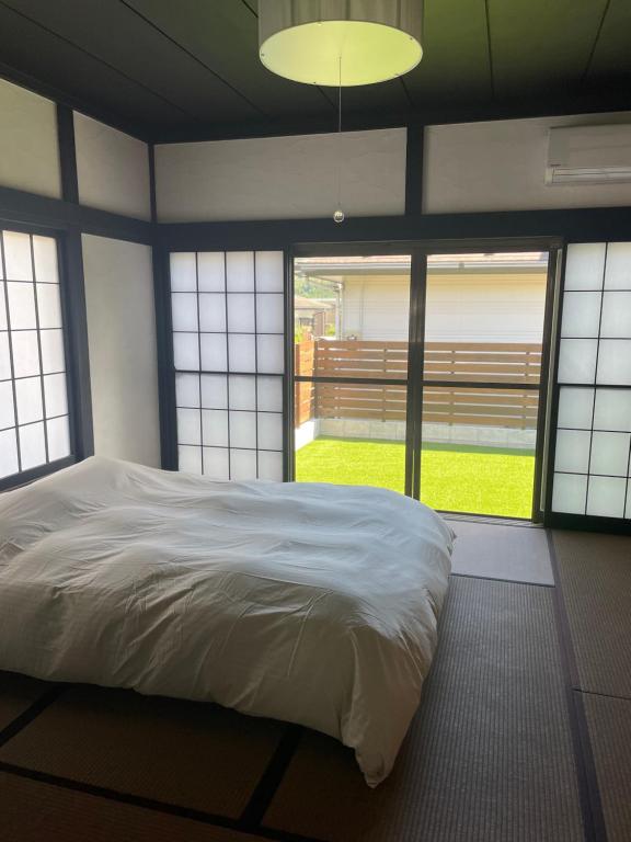 Sengokuhara貸切古民家Yukan的带一张白色大床和窗户的卧室