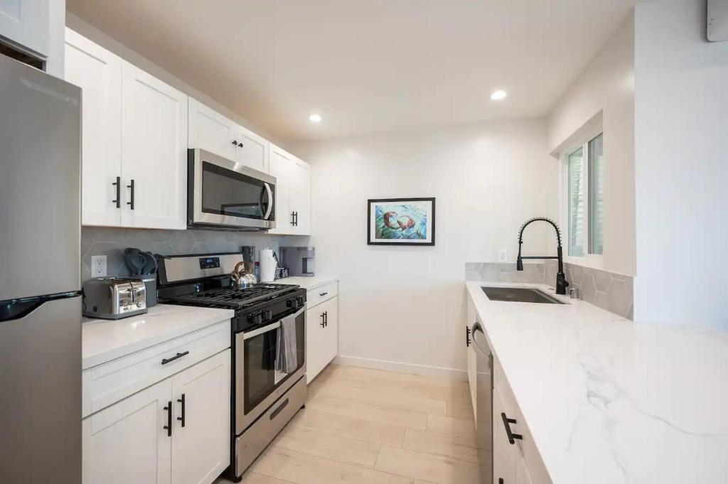 a white kitchen with white cabinets and a sink at Morro Bay Vacation Rentals in Morro Bay