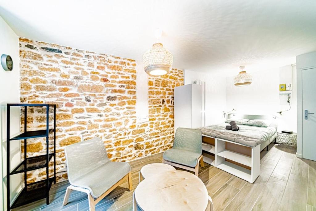 une pièce avec un mur de briques, une table et des chaises dans l'établissement Le petit Colbert-Studio cosy-Croix Rousse, à Lyon