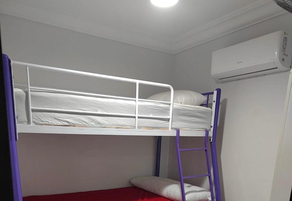 a bunk bed room with two bunk beds and a ladder at Porto golf marina ,2 bedrooms , Families only in El Alamein